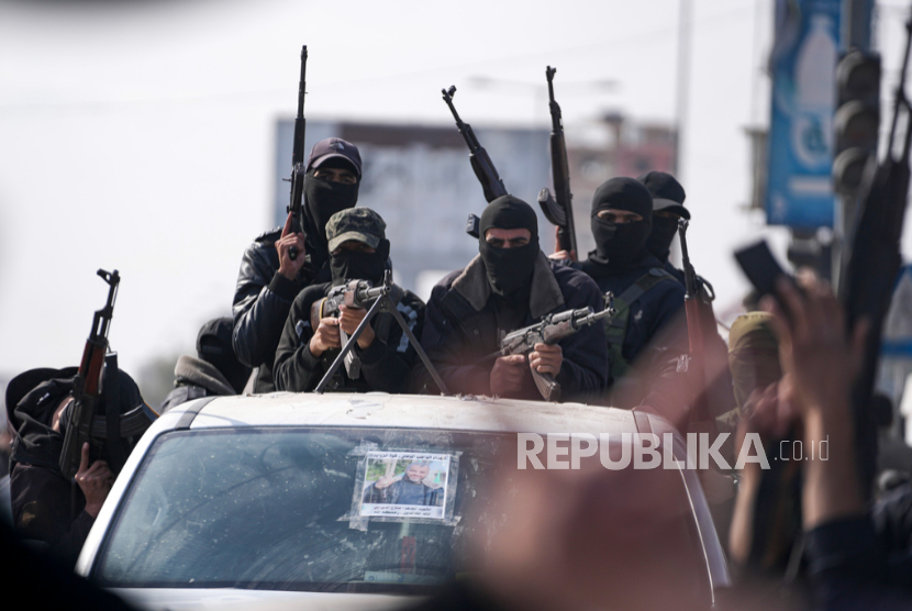 Anggota Brigade Izzuddin al-Qassam, sayap militer Hamas, mengambil bagian dalam parade merayakan gencatan senjata di Deir al-Balah, Jalur Gaza, Ahad , 19 Januari 2025.