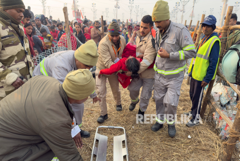 Petugas keamanan membawa seorang wanita keluar dari kerumunan di Sangam, pertemuan Sungai Gangga, Yamuna dan sungai mitos Saraswati,di Prayagraj, Uttar Pradesh , India, Rabu, 29 Januari 2025.