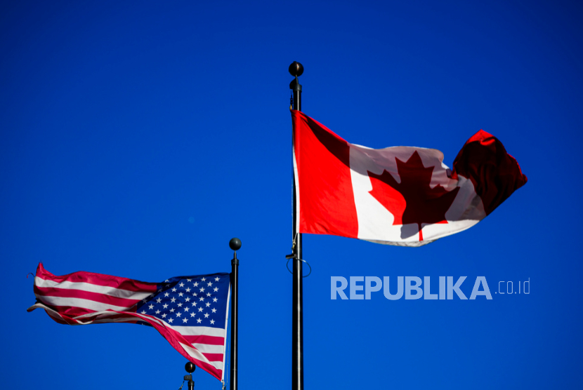 Bendera Kanada dan Amerika Serikat berkibar di luar sebuah hotel di pusat kota Ottawa, pada Sabtu, 1 Februari 2025. 