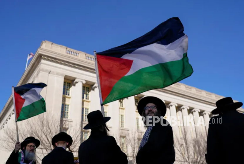 Warga Yahudi mengibarkan bendera Palestina saat mereka melakukan protes terkait kedatangan Perdana Menteri Israel Benjamin Netanyahu di Washington, DC, pada 4 Februari 2025.