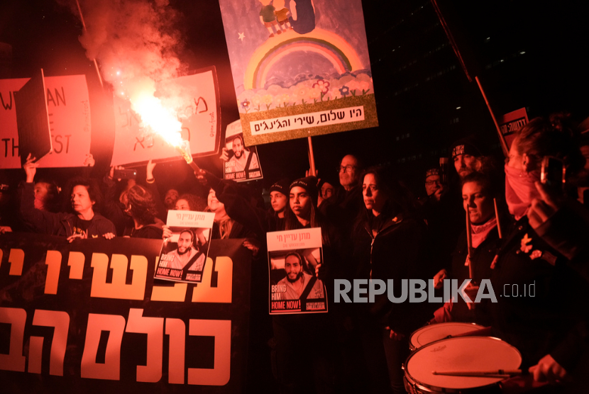 Demonstran menyalakan suar saat protes menuntut pembebasan segera sandera yang ditahan oleh Hamas di Jalur Gaza, di Tel Aviv, Israel, Sabtu, 22 Februari 2025.