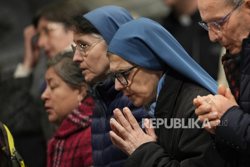 Jemaat dan biarawati berkumpul untuk mendoakan Paus Fransiskus di Basilika Santo Yohanes Lateran di Roma, Ahad, 23 Februari 2025.