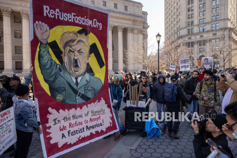 Para pengunjuk rasa membawa poster Donald Trump sebagai Hitler dalam aksi mendukung aktivis Palestina Mahmoud Khalil, Senin, 10 Maret 2025, di New York.