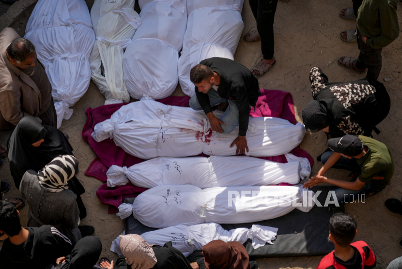 Para pelayat berkumpul di sekitar jenazah warga Palestina yang terbunuh akibat serangan udara tentara Israel saat mereka dibawa ke Rumah Sakit Al-Ahli di Kota Gaza, Selasa, 18 Maret 2025.