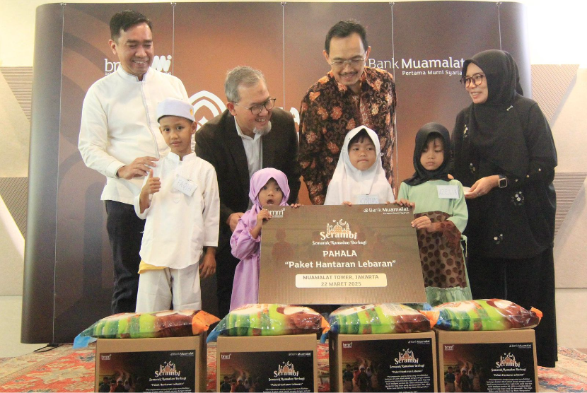 Anggota Board of Management PT Bank Muamalat Indonesia Tbk Imam Teguh Saptono (kedua kiri) dan Karno (kiri) bersama Guru Besar Institut Tazkia Prof. Dr. Syafii Antonio (kedua kanan) serta Executive Director Baitulmaal Muamalat Supriati Nugroho Pernamawati (kanan) menyerahkan secara simbolis Paket Hantaran Lebaran (Pahala) kepada anak-anak yatim piatu di Jakarta, Sabtu (22/3/2025). Bank Muamalat menutup rangkaian kegiatan literasi dan inklusi keuangan syariah 