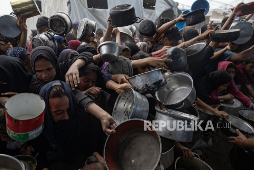 Pengungsi Palestina mengantri untuk menerima sebagian makanan dari dapur amal di Khan Yunis, Jalur Gaza selatan, Jumat, 2 Mei 2025.