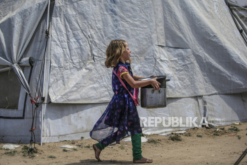 Seorang anak pengungsi Palestina setelah menerima sebagian makanan dari dapur amal, di Jabalia, Jalur Gaza utara, Jumat, 2 Mei 2025.