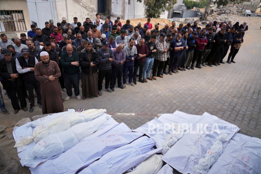 Warga Palestina mendoakan jenazah pria, wanita, dan anak-anak yang syahid dalam dua serangan terpisah tentara Israel, di rumah sakit Al-Shifa di Kota Gaza, Senin, 5 Mei 2025.