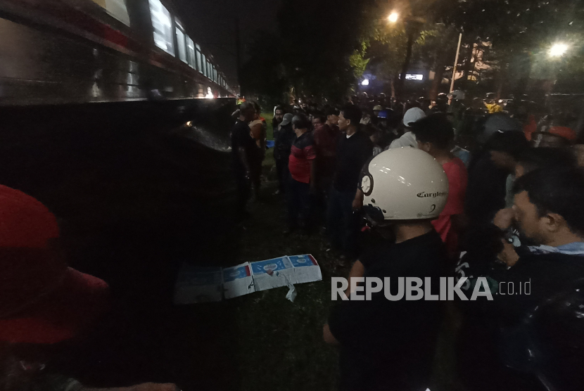 Warga mengelilingi jenazah bocah korban tertabrak kereta di Rawajati, Jakarta Selatan, Selasa (7/5/2025).