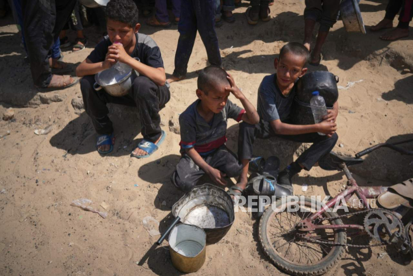 Warga Palestina berjuang untuk mendapatkan sumbangan makanan di dapur komunitas di Khan Younis, di selatan Jalur Gaza, Jumat, 9 Mei 2025.