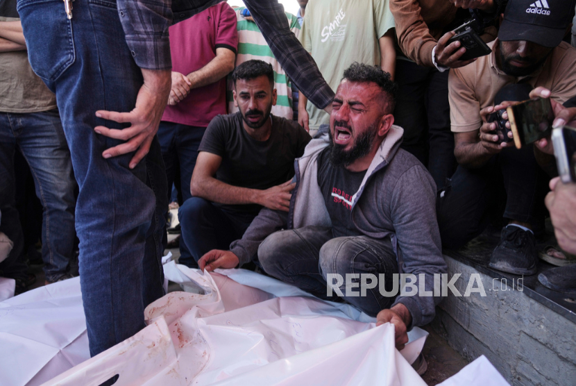 Osama Abu Mosabbah, berduka atas istri dan dua anaknya yang syahid dalam serangan udara Israel, saat pemakaman mereka di Rumah Sakit Al-Aqsa di Deir al-Balah, Gaza, Selasa, 20 Mei 2025.