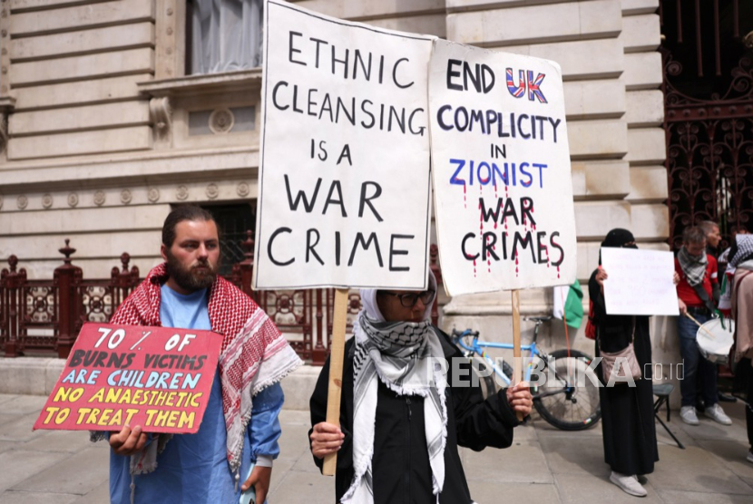 Pengunjuk rasa memegang plakat dan bendera Palestina saat melakukan protes di luar Kantor Luar Negeri dan Persemakmuran di London, Inggris, 21 Mei 2025.