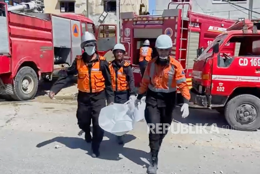 Pekerja mengumpulkan sisa-sisa jenazah setelah serangan Israel di sebuah rumah menewaskan sembilan dari sepuluh anak seorang dokter di Khan Younis, Jalur Gaza, Sabtu, 24 Mei 2025.