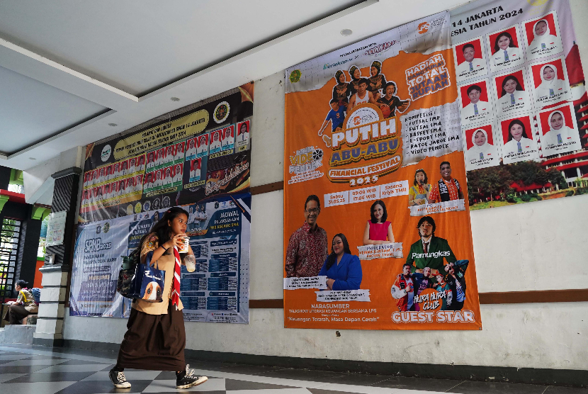 Siswa melintas di samping banner “LPS Putih Abu-Abu Financial Fest” di SMAN 14 Jakarta, Rabu (28/5/2025). 