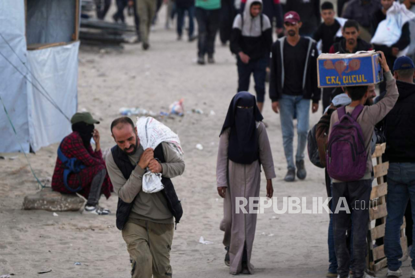 Warga Palestina membawa tas berisi makanan dan bantuan kemanusiaan di Khan Younis, Jalur Gaza selatan, pada Selasa, 3 Juni 2025.