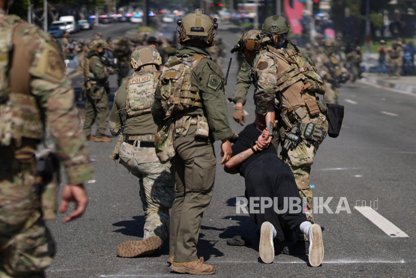 Polisi menahan seorang pria saat protes di Paramount, California, Sabtu, 7 Juni 2025, setelah otoritas imigrasi federal melakukan operasi. 