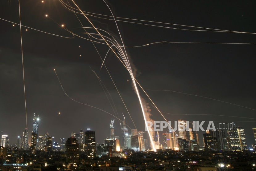 Sebuah proyektil menghantam bangunan saat sistem pertahanan udara Iron Dome Israel mencoba mencegat rudal Iran di Tel Aviv, Israel, Jumat, 13 Juni 2025. 