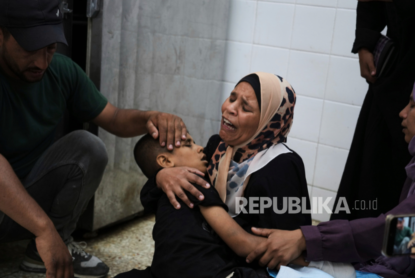 Sherine Abu Mor, memeluk jenazah putranya, Hamza Al-Shaer, yang syahid akibat serangan udara tentara Israel, di Rumah Sakit Al-Aqsa di Deir al-Balah, Jalur Gaza, Sabtu, 14 Juni 2025.