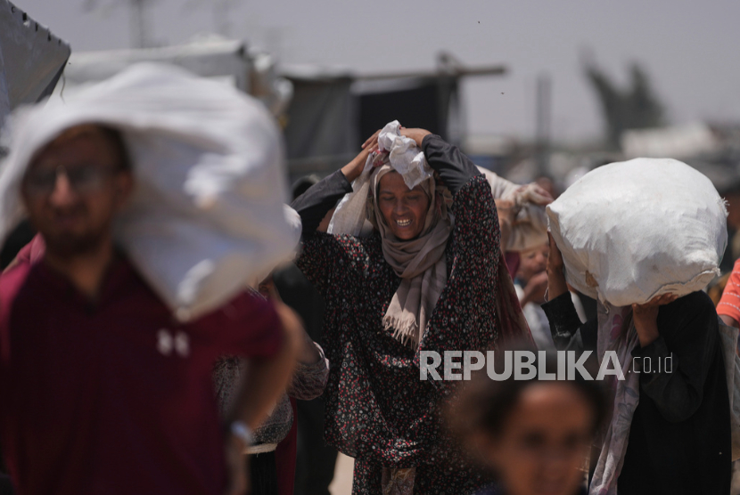 Warga Palestina membawa tas berisi makanan dan paket bantuan kemanusiaandi Rafah, Jalur Gaza selatan, Senin, 16 Juni 2025. 