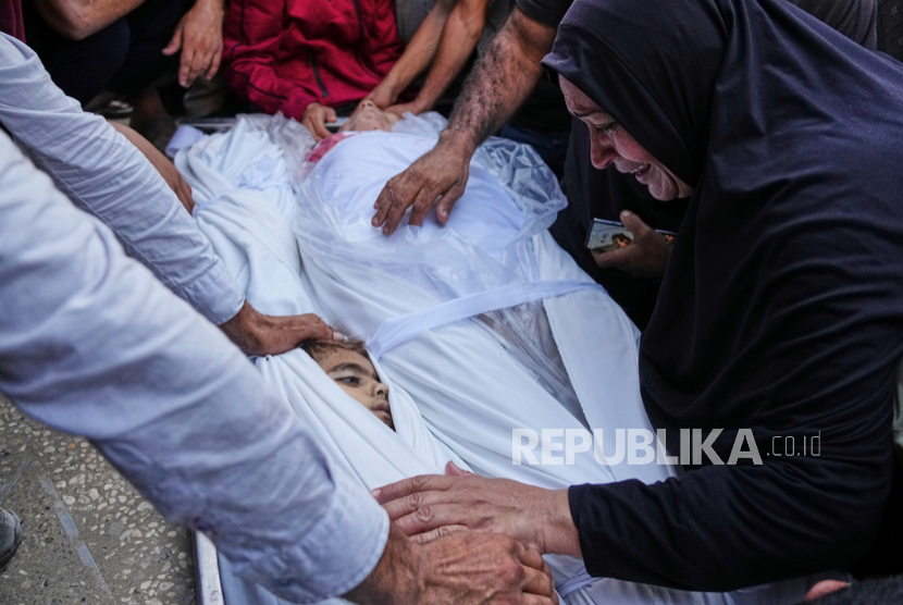 Seorang wanita Palestina menyaksikan pemakaman seorang anak yang syahid akibat serangan militer Israel di Gaza, di Rumah Sakit Al-Shifa di Kota Gaza, Kamis, 19 Juni 2025. 