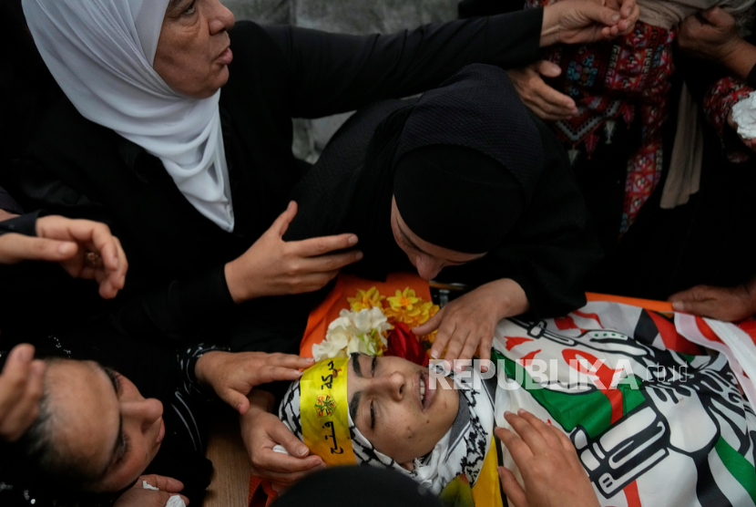 Para pelayat mendukai jenazah warga Palestina Ammar Hamayel, 13 tahun, yang ditembak mati oleh tentara Israel pada hari Senin, saat pemakamannya di desa Kafr Malik, Tepi Barat,  Selasa, 24 Juni 2025.