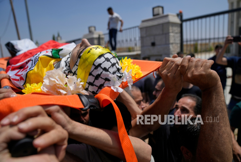 Para pelayat mendukai jenazah warga Palestina Ammar Hamayel, 13 tahun, yang ditembak mati oleh tentara Israel pada hari Senin, saat pemakamannya di desa Kufr Malek, Tepi Barat,  Selasa, 24 Juni 2025.