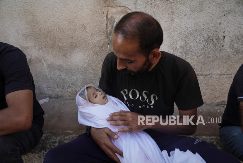 Seorang pria Palestina menggendong jenazah keponakan bayinya, Yahya Siam, yang syahid akibat serangan udara Israel di Kota Gaza, Senin, 7 Juli 2025.