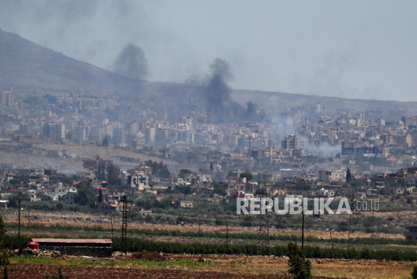 Asap mengepul dari bentrokan antara pasukan pemerintah Suriah dan milisi Druze di kota Sweida, Suriah selatan, Selasa, 15 Juli 2025.