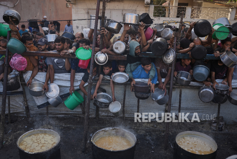 Warga Palestina menunggu makanan yang disumbangkan di dapur umum di Kota Gaza, di Jalur Gaza utara, Senin, 14 Juli 2025. 