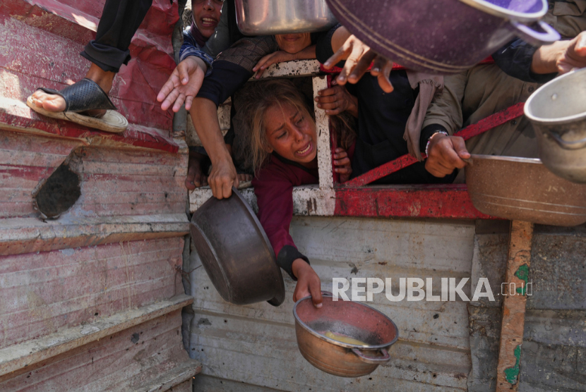 Warga Palestina berjuang untuk mendapatkan sumbangan makanan di dapur umum, di Kota Gaza, Jalur Gaza utara, Sabtu, 26 Juli 2025. 