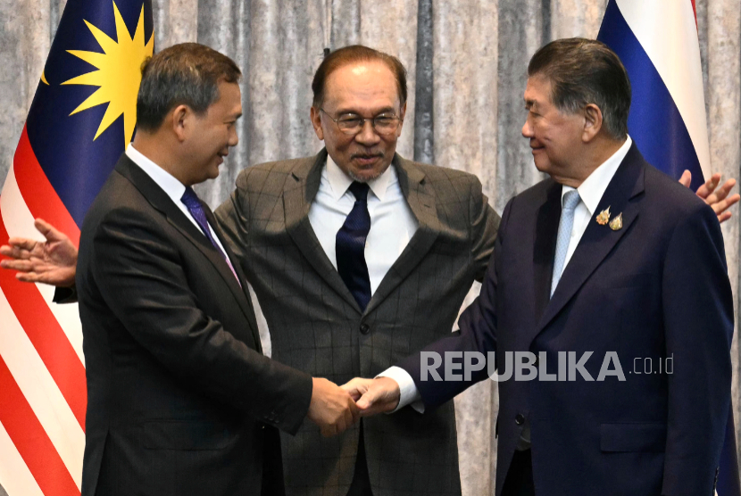PM Kamboja Hun Manet (kiri) dan penjabat PM Thailand Phumtham Wechayachai berjabat tangan disaksikan PM Malaysia Anwar Ibrahim selepas menyepakati gencatan senjata di Putrajaya, Malaysia, Senin, 28 Juli 2025.