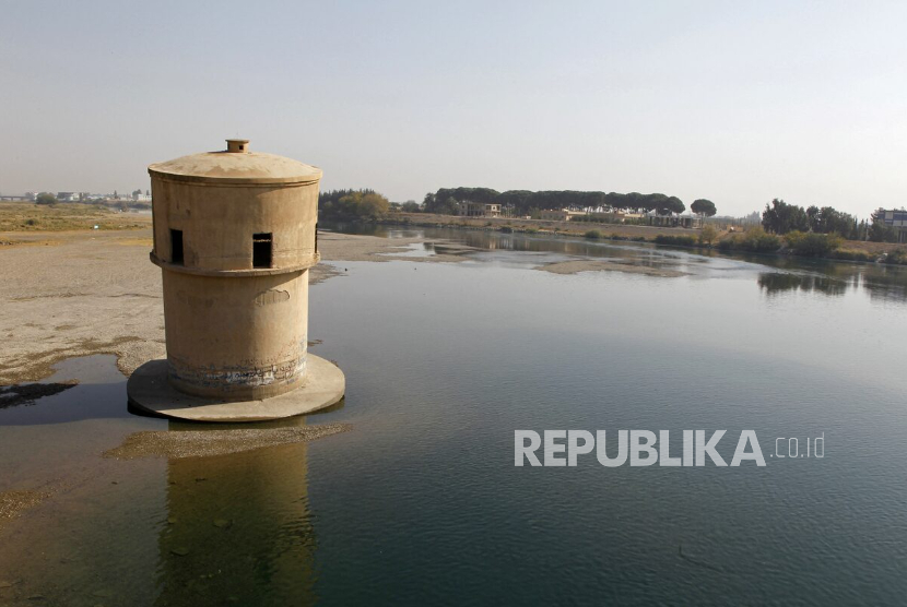 Pemandangan surutnya air sungai Efrat dekat kota Raqqa di Suriah timur, pada 2024 dengan tanda di menara observasi tua yang menunjukkan tingkat air yang lebih tinggi di masa lalu.