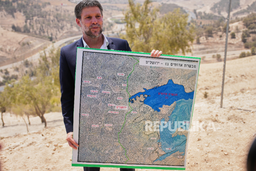 Menteri Keuangan Israel Bezalel Smotrich memegang peta yang menunjukkan proyek pemukiman E1 saat konferensi pers di dekat pemukiman Maale Adumim, di Tepi Barat yang diduduki Israel, Kamis, 14 Agustus 2025.