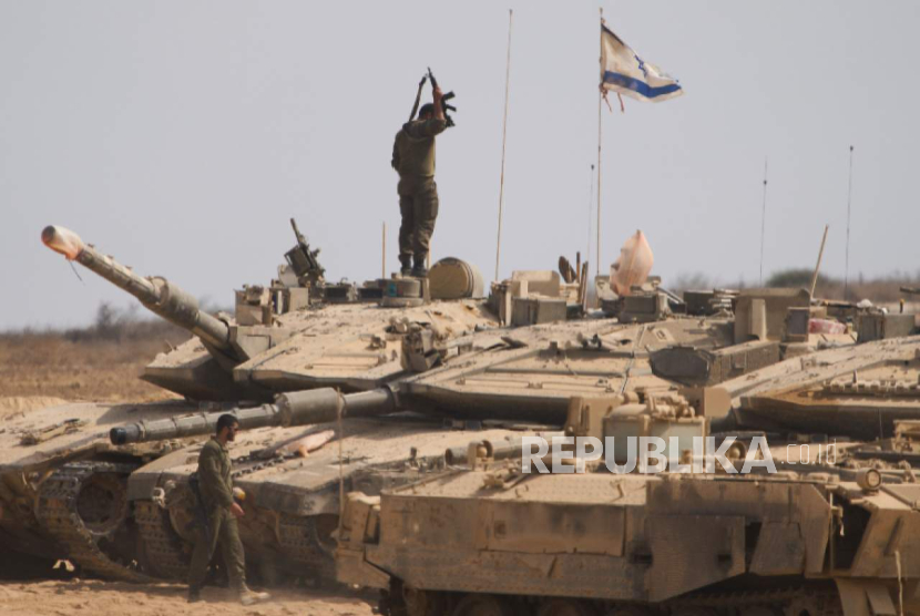 Tentara Israel mengerjakan tank mereka di area persiapan di perbatasan dengan Jalur Gaza, di Israel selatan, Rabu, 13 Agustus 2025.