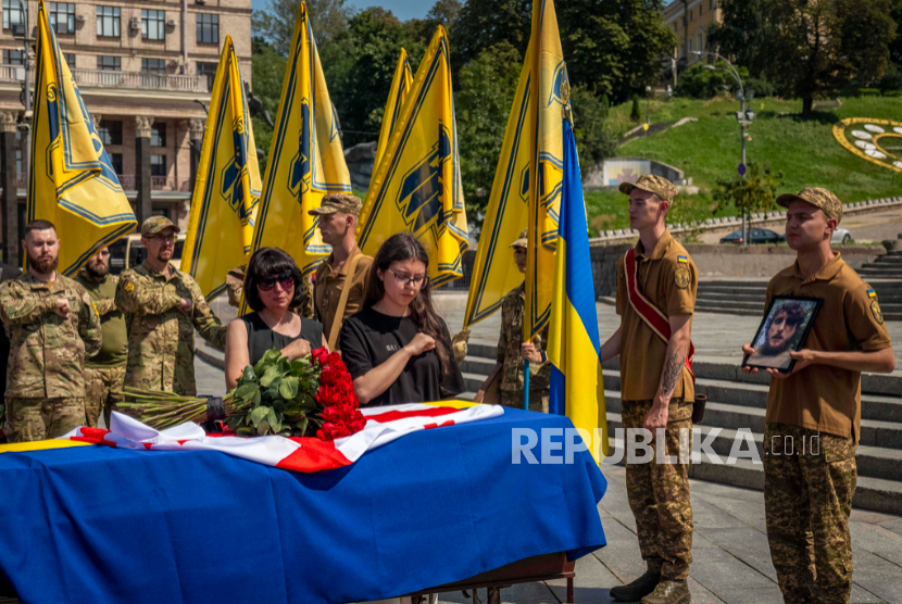 Kerabat memberikan penghormatan terakhir di dekat peti mati tentara sukarelawan Ukraina Georgia Mykhailo Kovaliv, dalam upacara perpisahan di Lapangan Kemerdekaan di Kyiv, Ukraina, Sabtu, 9 Agustus 2025. 