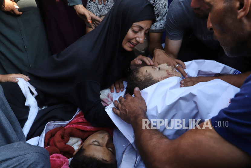Amna Foujo berduka atas jenazah kedua anaknya, Abdullah (10 tahun) dan Awad Foujo (13), yang syahid akibat serangan Israel , saat pemakaman mereka di luar Rumah Sakit Nasser di Khan Younis, Jalur Gaza selatan, Sabtu, 23 Agustus 2025.