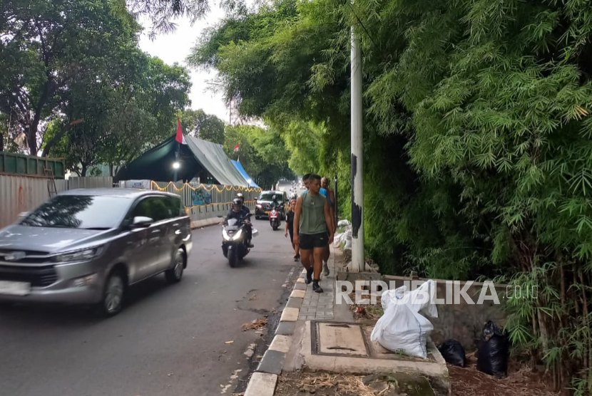 Warga berjalan melintasi trotoar di Jalan Simatupang, Jakarta Selatan, Ahad (24/8/2025).