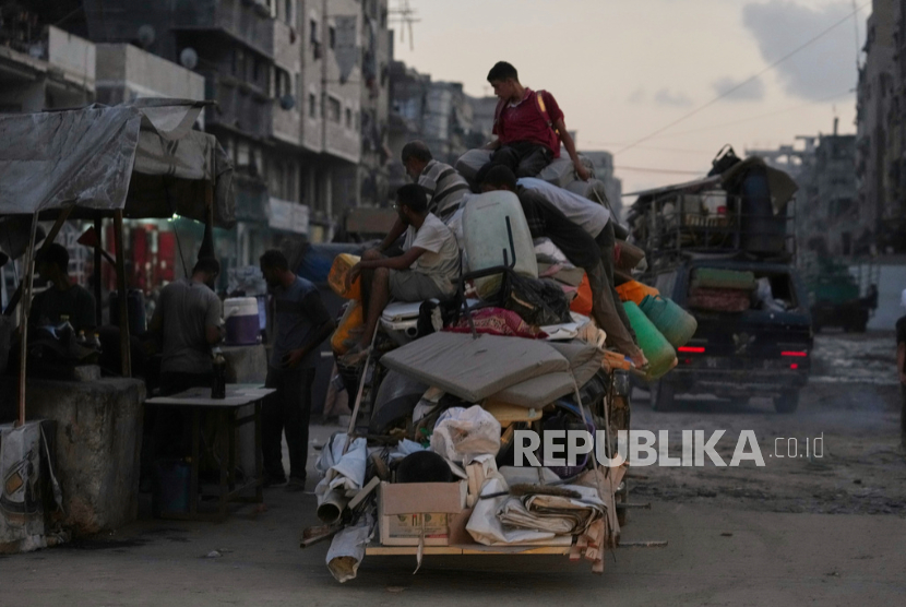 Pengungsi Palestina yang melarikan diri dari Jabaliya membawa barang-barang mereka di sebuah jalan di Kota Gaza, Selasa, 26 Agustus 2025.