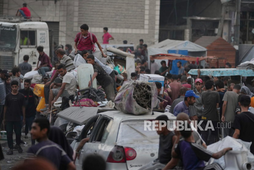 Palestinian refugees fleeing Jabaliya carry their belongings on a street in Gaza City, Tuesday, August 26, 2025.