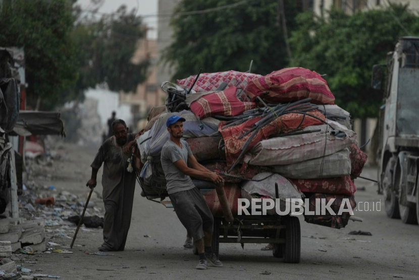 Pengungsi Palestina yang melarikan diri dari Jabaliya membawa barang-barang mereka di sebuah jalan di Kota Gaza, Selasa, 26 Agustus 2025.