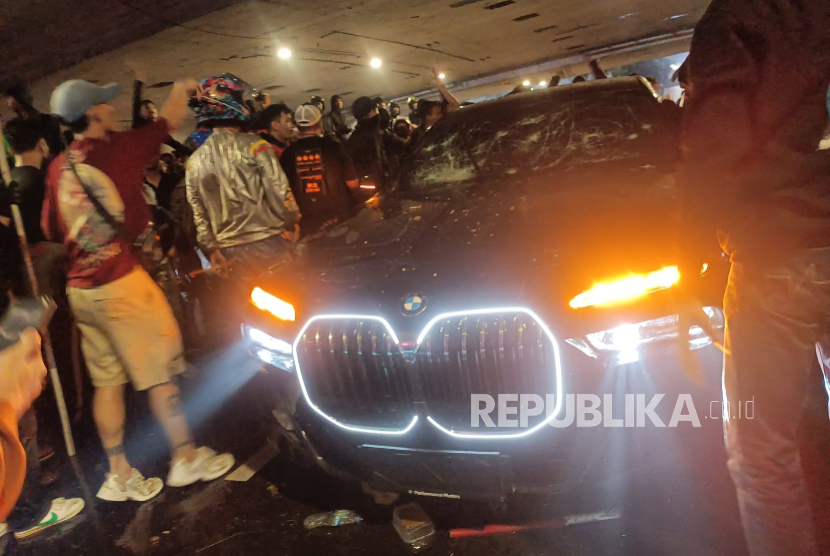 Mobil BMW jadi sasaran amuk massa aksi Polda Metro Jaya saat melewati jalan di bawah jembatan simpang lima, Jakarta, Jumat (29/8/2025) pukul 19.40 WIB. 