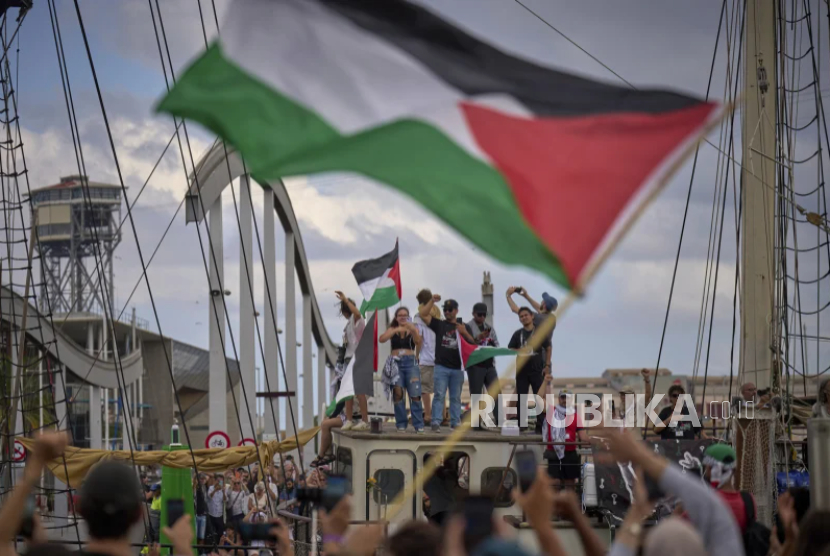 Aktivis melambai dari perahu yang ikut serta dalam armada sipil menuju Gaza, di Barcelona, ??Spanyol, Ahad, 31 Agustus 2025.