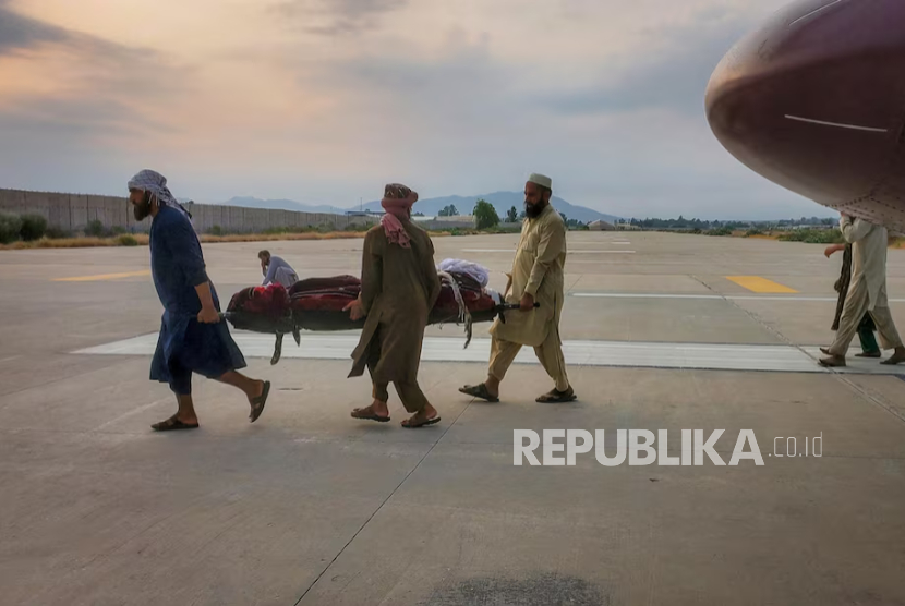 Orang-orang membawa korban gempa dengan tandu ke ambulans di bandara Jalalabad, Afghanistan, 1 September 2025. 