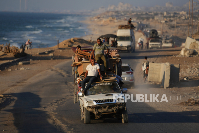 Pengungsi Palestina yang melarikan diri dari Jalur Gaza utara membawa barang-barang mereka di sepanjang Jalan Laut, di Gaza tengah, Kamis, 4 September 2025.