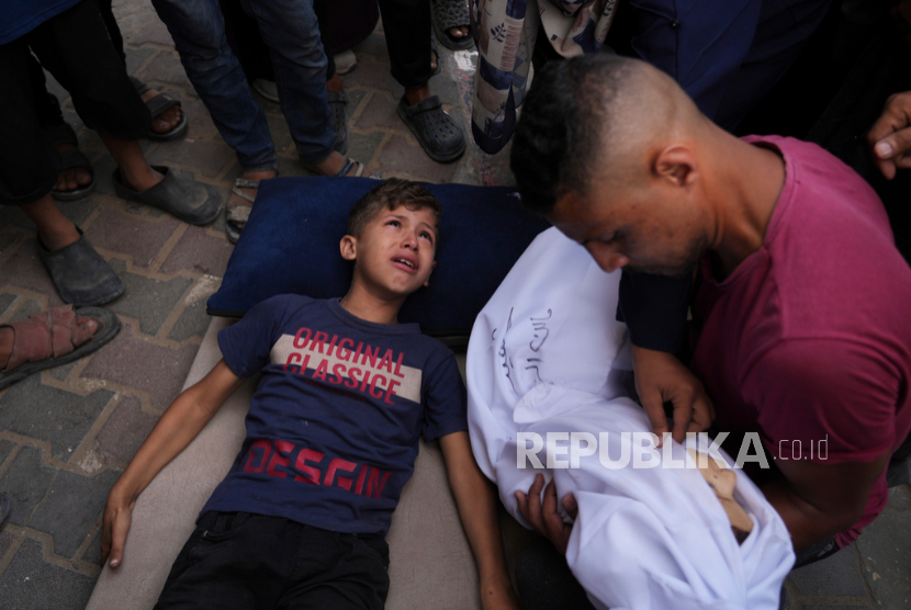 Jenazah anak berusia 2 tahun, Malek Al-Zaqzouq, yang syahid dalam serangan militer Israel, ditangisi abangnya sebelum pemakamannya di Rumah Sakit Al-Aqsa di Deir al-Balah, di Jalur Gaza tengah, Senin, 22 September 2025. 
