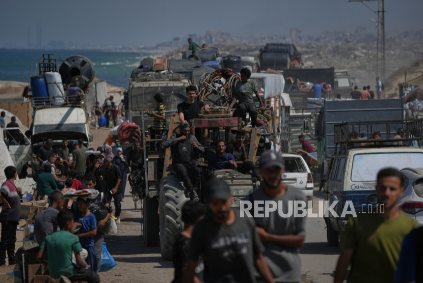 Pengungsi Palestina meninggalkan Jalur Gaza utara sambil berjalan membawa barang-barang mereka di sepanjang jalan pantai, dekat Wadi Gaza, Rabu, 24 September 2025. 