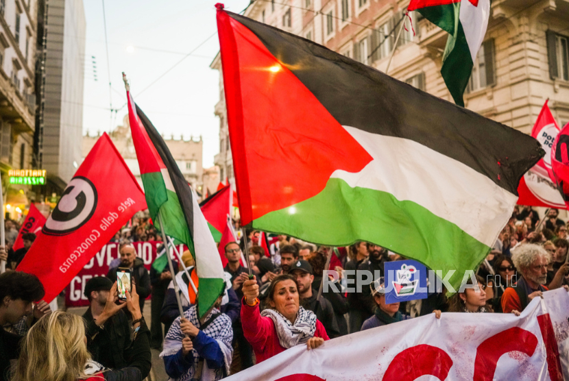 Seorang wanita mengibarkan bendera Palestina saat demonstrasi pro-Global Sumud Flotilla di pusat kota Roma, Kamis, 25 September 2025.
