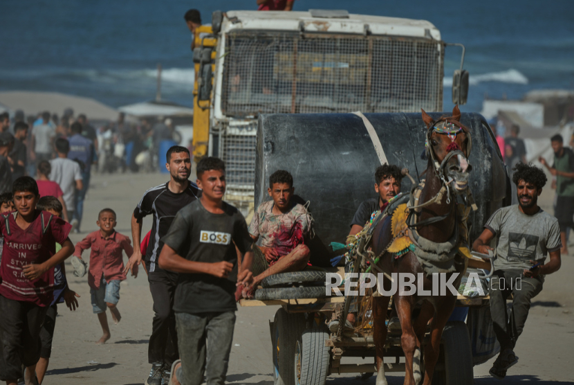 Warga membawa korban luka akibat serangan militer Israel  yang menyasar para pengungsi di Kota Gaza, Rabu, 1 Oktober 2025.