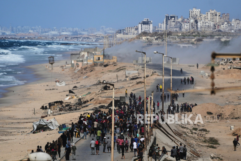 Pengungsi Palestina berkumpul di jalan pesisir dekat Wadi Gaza setelah pengumuman bahwa Israel dan Hamas telah menyetujui tahap pertama rencana, di Jalur Gaza tengah, Kamis, 9 Oktober 2025.
