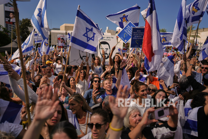 Warga Israel menonton siaran langsung sandera Israel yang dibebaskan dari Gaza di Tel Aviv, Israel, Senin, 13 Oktober 2025.